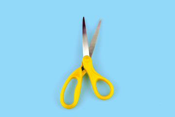 Yellow scissors isolated on blue  background