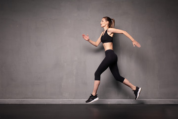 Fototapeta na wymiar young woman doing exercise on grey background