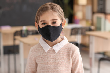 Little girl wearing medical mask at school