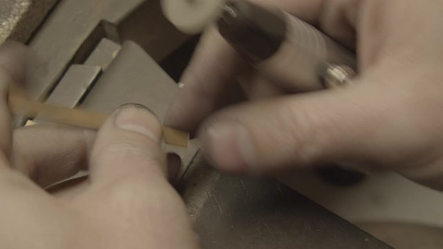  Jeweler polishes a gold piece with the small brush 
