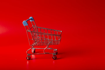 Empty Groceries trolley on red background