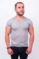 Fototapeta premium Portrait of muscular bearded man thinking and looking up