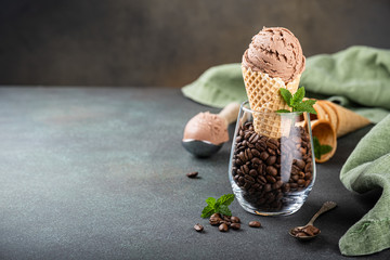 Delicious coffee or chocolate ice cream in waffle cone for dessert. Summer healthy food concept, lactose free. Copy space.