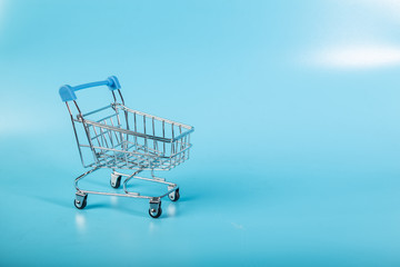 Empty Groceries trolley on blue background