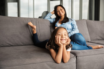 Obraz premium Photo of woman with her daughter smiling while resting on couch
