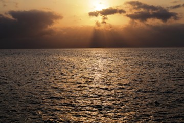Obraz premium Luci del tramonto verso il mare all'isola d'Elba, Italia, con bellissimi colori e raggi di sole tra le nuvole e riflessi sull'acqua