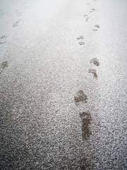 Prints of a man's shoes in the snow.