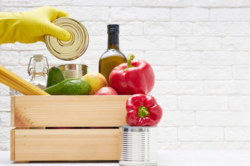 Food stocks in a wooden box. Vegetables,oil ,fruits, canned food, pasta. Donation , food delivery, coronavirus