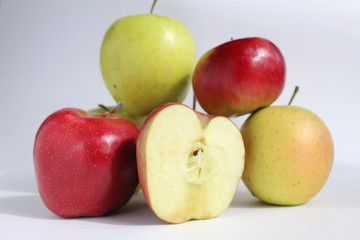red green and yellow apples on a white background