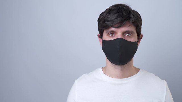 Man in a black medical mask, isolated on a gray background