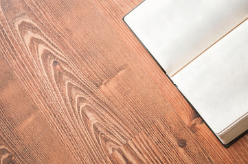 open book on a wooden background. holy bible on the table. notepad pages on the floor
