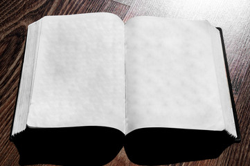 open book on a wooden background. holy bible on the table. notepad pages on the floor