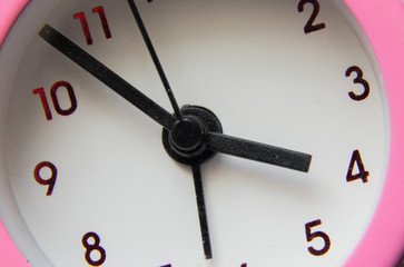 pink alarm clock close-up on an isolated background