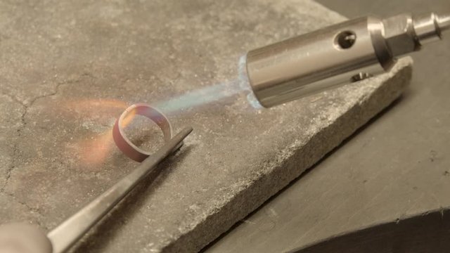 jeweler soldering a golden ring