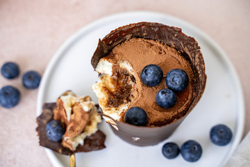 Tiramisu dessert in chocolate cup with berries