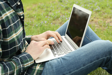 Man with laptop works in park. Outdoor work