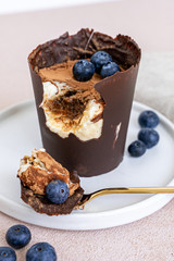 Tiramisu dessert in chocolate cup with berries