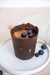 Tiramisu dessert in chocolate cup with berries