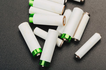 Close the positive poles of the used battery on a black background.