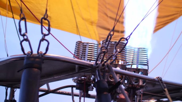 Gas burners blast flames to inflate a hot air balloon before dawn