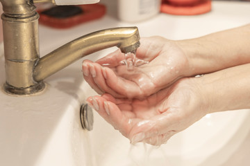 Washing hands under the faucet with water. Washing hands with soap and water. Hand hygiene concept