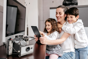 Middle-age mother with her children using digital tablet in workspace