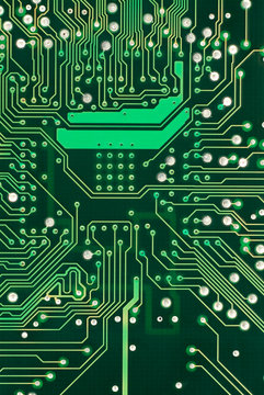 A detailed image of a small green microchip circuit board.