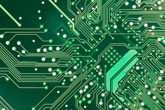 A detailed image of a small green microchip circuit board.