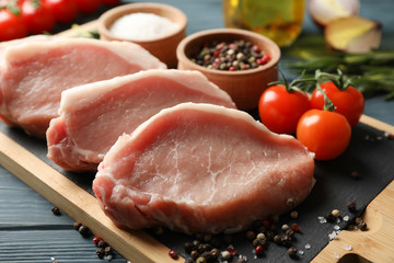 Composition with raw meat for steak and ingredients on wooden background