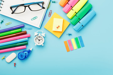 Office supplies lie on a blue background. To study in school. Rainbow color.