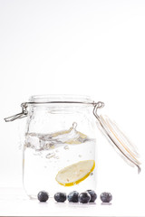 transparent water bottle with lemon slice falling at high speed