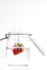 clear water can piece of fresh strawberry falling at high speed