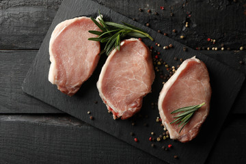 Composition with raw meat for steak and spices on wooden background