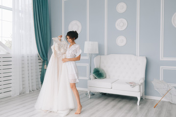 Fototapeta premium boudoir portrait of a young girl in a dressing gown, morning gatherings of the bride, fitting a wedding dress, young brunette, tender photo, wedding portrait,
