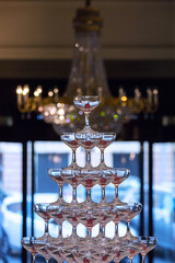 a pile of glasses with cherries on the background of the chandelier in the hotel lobby