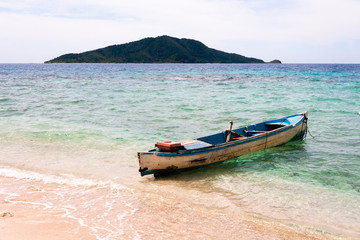 Fototapeta na wymiar Abandoned fish boats in the turquoise sea