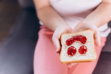 Children hand's holding sandwich with jam. Children breakfast at home