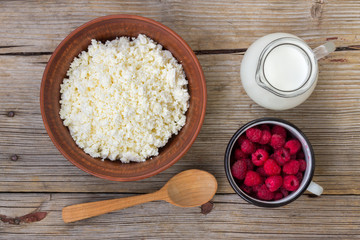 Healthy breakfast items. Oatmeal, milk, fresh berries and cottage cheese. Overhead view, rustic style