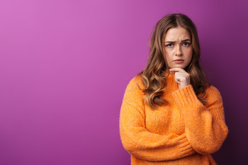 Portrait of a lovely young girl wearing sweater standing isolated