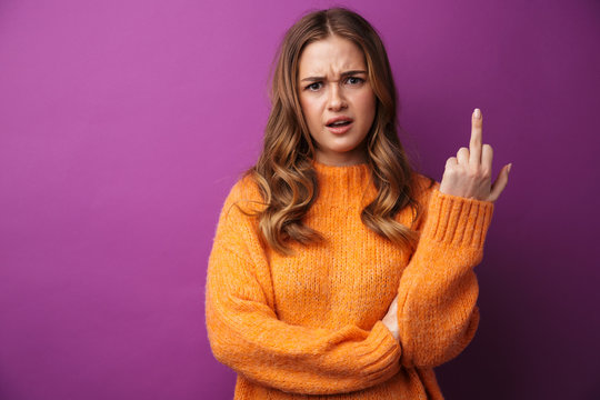 Image of angry young woman frowning and gesturing middle finger