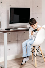 A young boy holding a phone looking at camera in his work zone