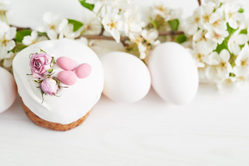 Fototapeta na wymiar Easter sweet bread, Easter cake with flowers and gingerbread. Holidays breakfast concept with copy space. Easter greeting card template. Homemade pasques.Easter sweets on white background.