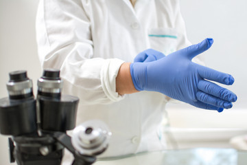 Medical worker wearing protective gloves in laboratory.