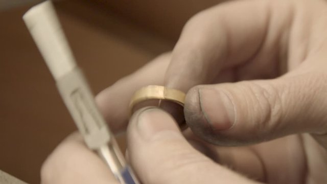 Close up of repairing ring by a small plier. Master goldsmith working process. Jewelry concept. Close up