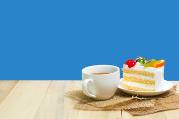 Slice cake with coffee cup on wood ,  blue background