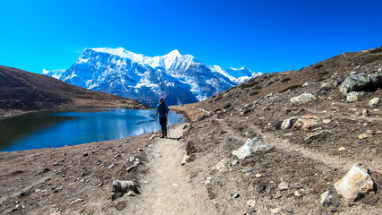 A man trekking along the Ice Lake, Annapurna Circuit Trek detour, Himalayas, Nepal, surrounded by...