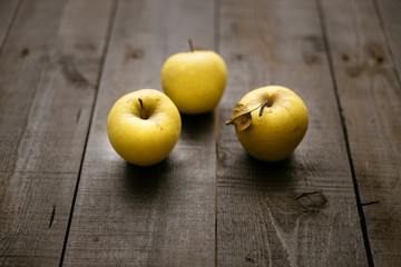 Golden delicious apples on dark wooden rustic table from above