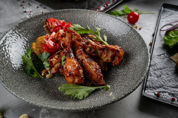 Baked chicken wings in pan on wooden table.