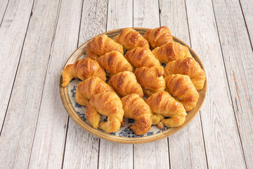 plate of croissants on white wooden table