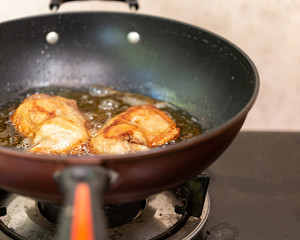 Fry the chicken in a pan with boiling oil.